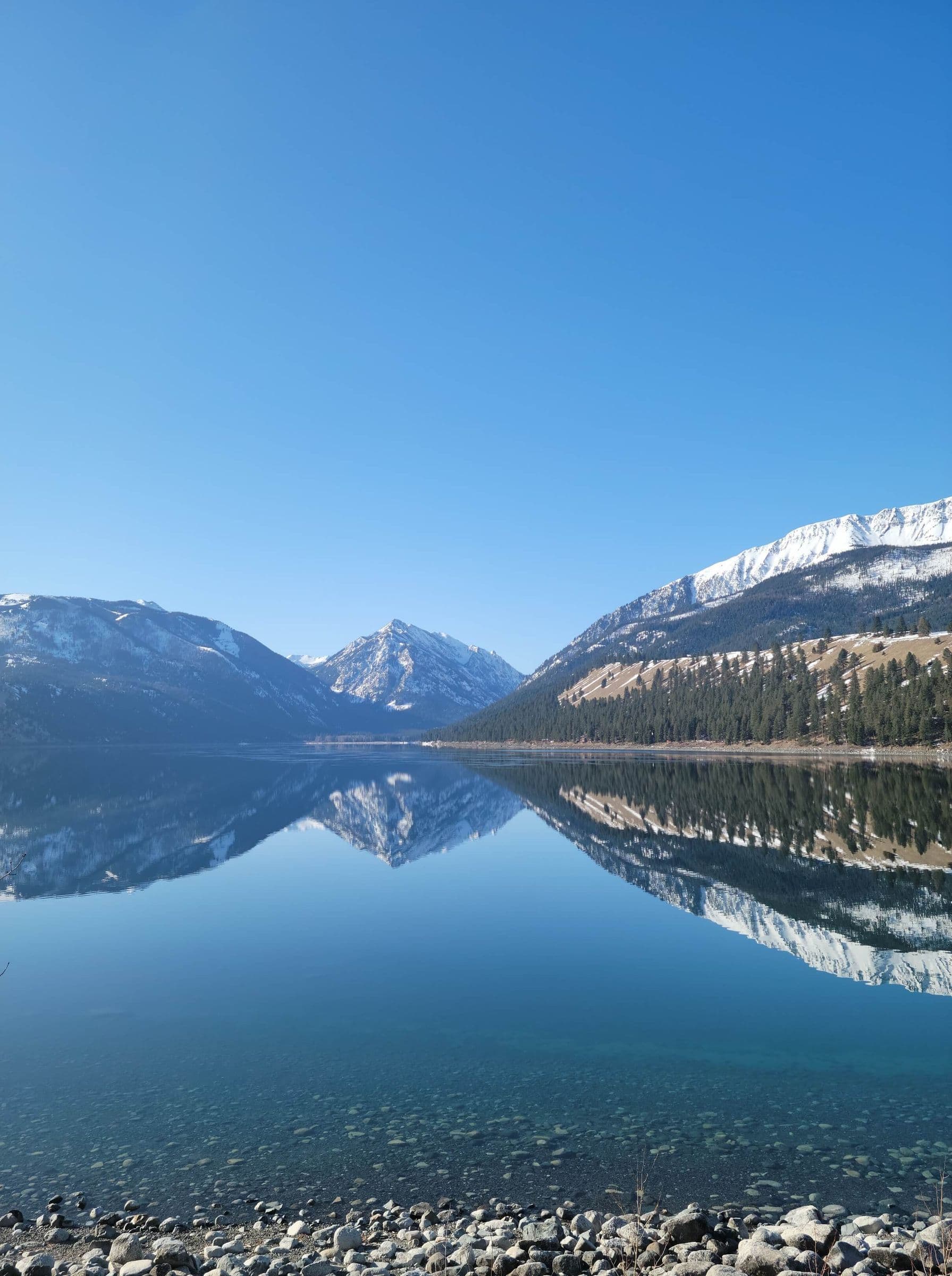 Mountain capped views in the distance reflecting over the crystal clear waters of Wallowa Lake