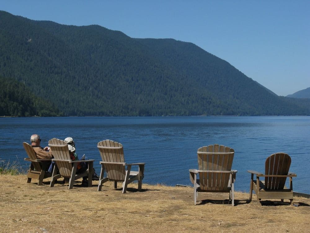 Adirondeck chairs sitting along the shoreline of Lake Crescent