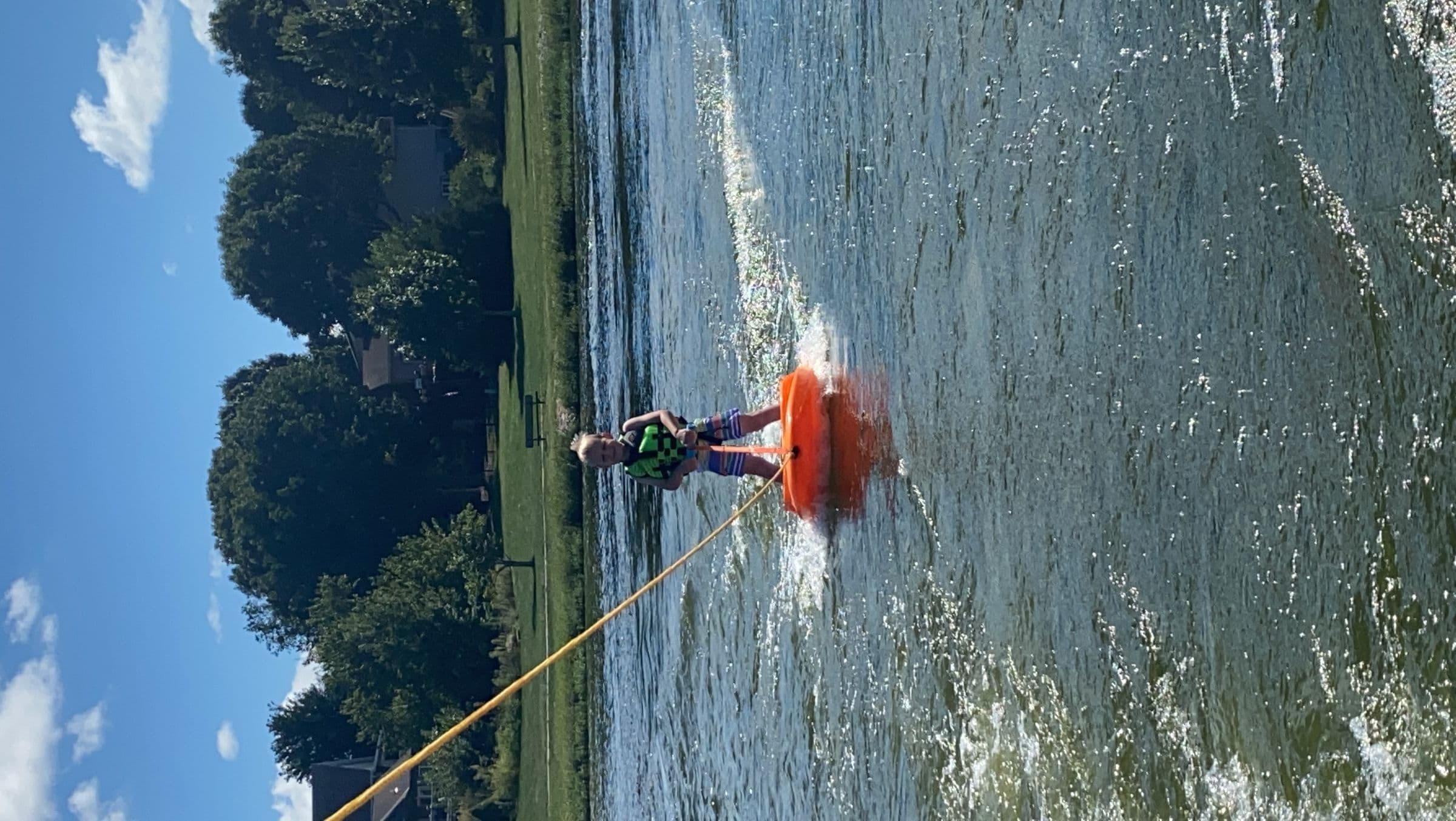 Kid on a wakeboard behind a boat