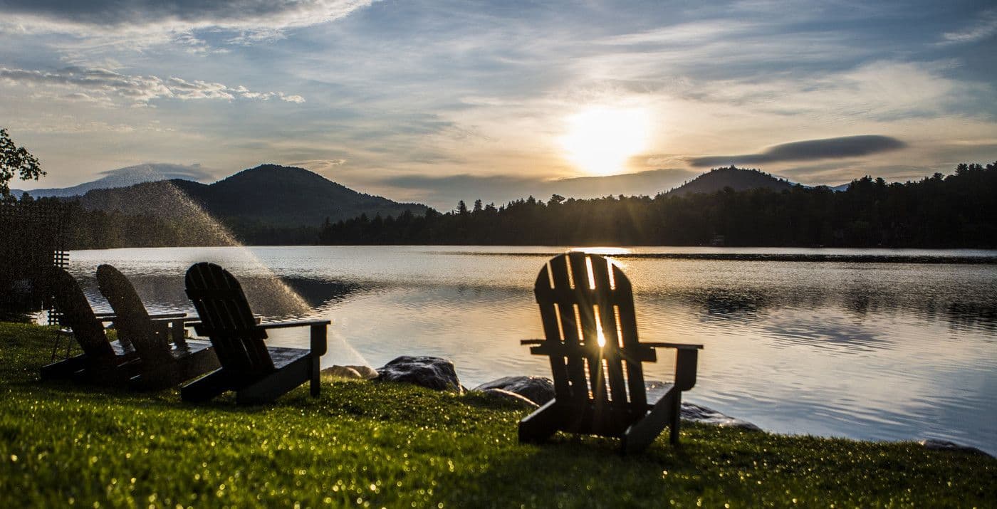 Mirror Lake at Sunset with adirondeck chairs in front of the water