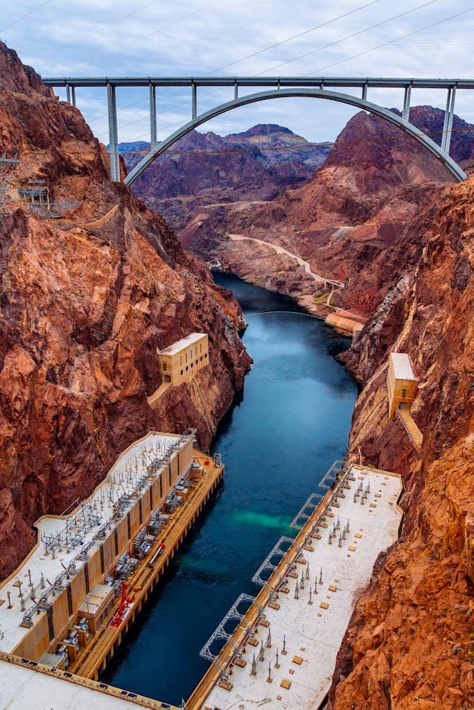 A picturesque landscape of the Hoover Dam with the Mike O'Callaghan–Pat Tillman Memorial Bridge looming overhead.