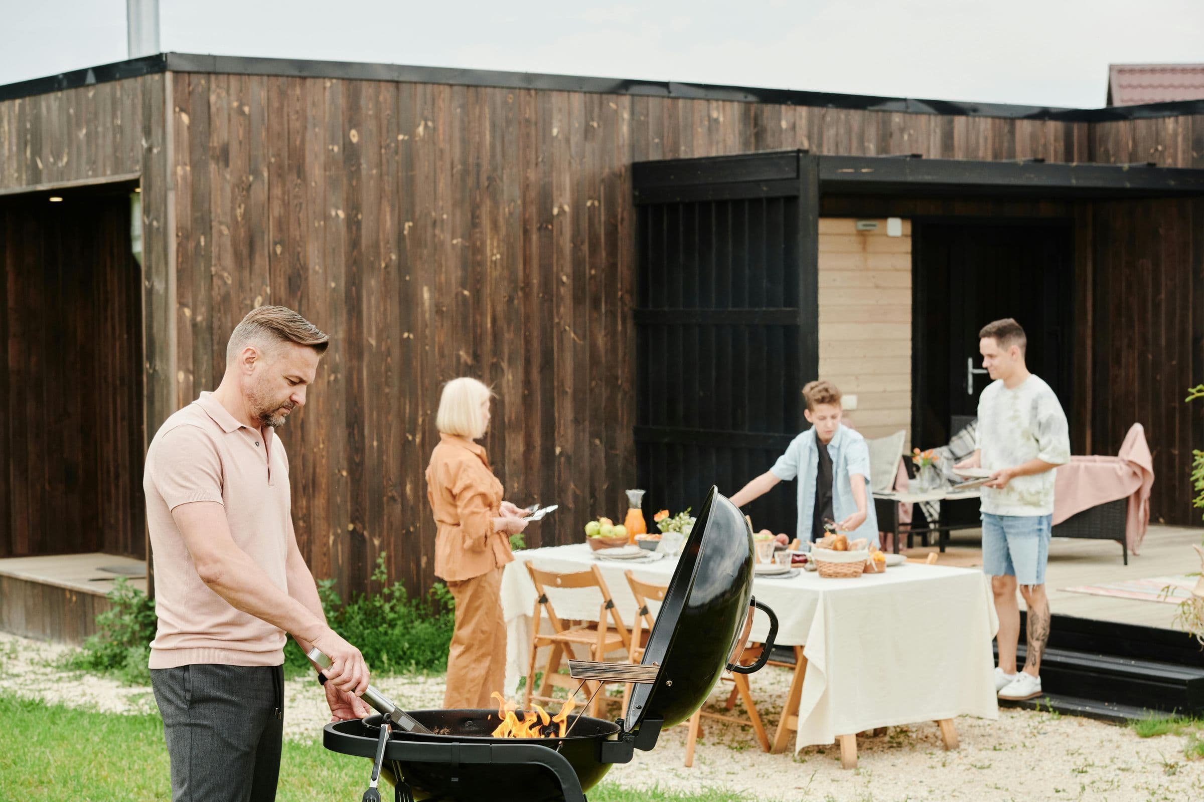 Family cooking together by a grill
