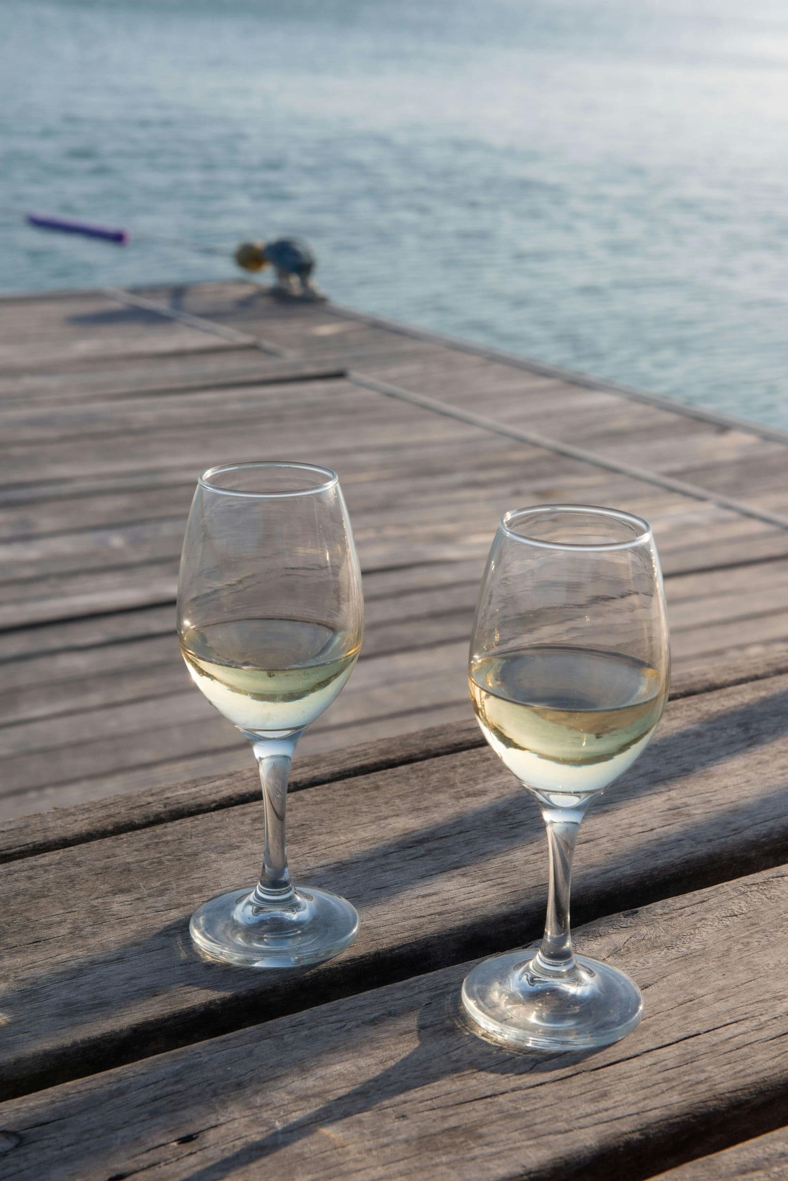 Two wine glasses on a lake dock