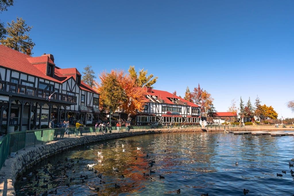 Picturesque Lake Arrowhead Village with autumn foliage and ducks by the lakeside.