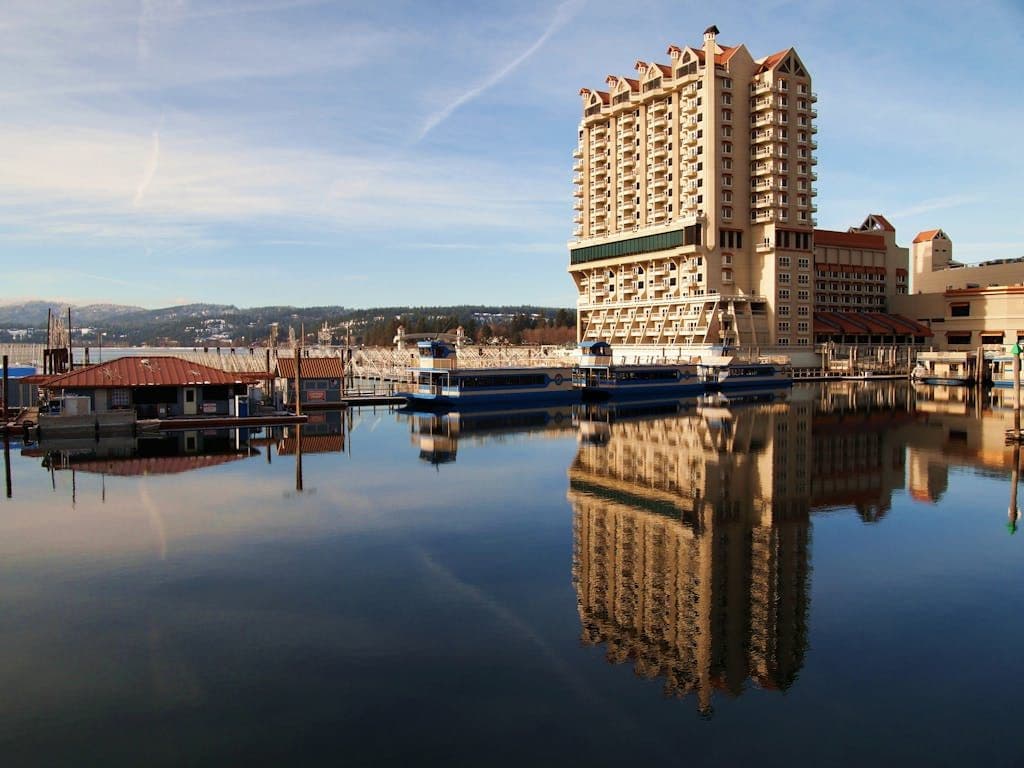 Scenic view of Coeur d'Alene Resort reflecting on calm lake waters in Idaho, USA.
