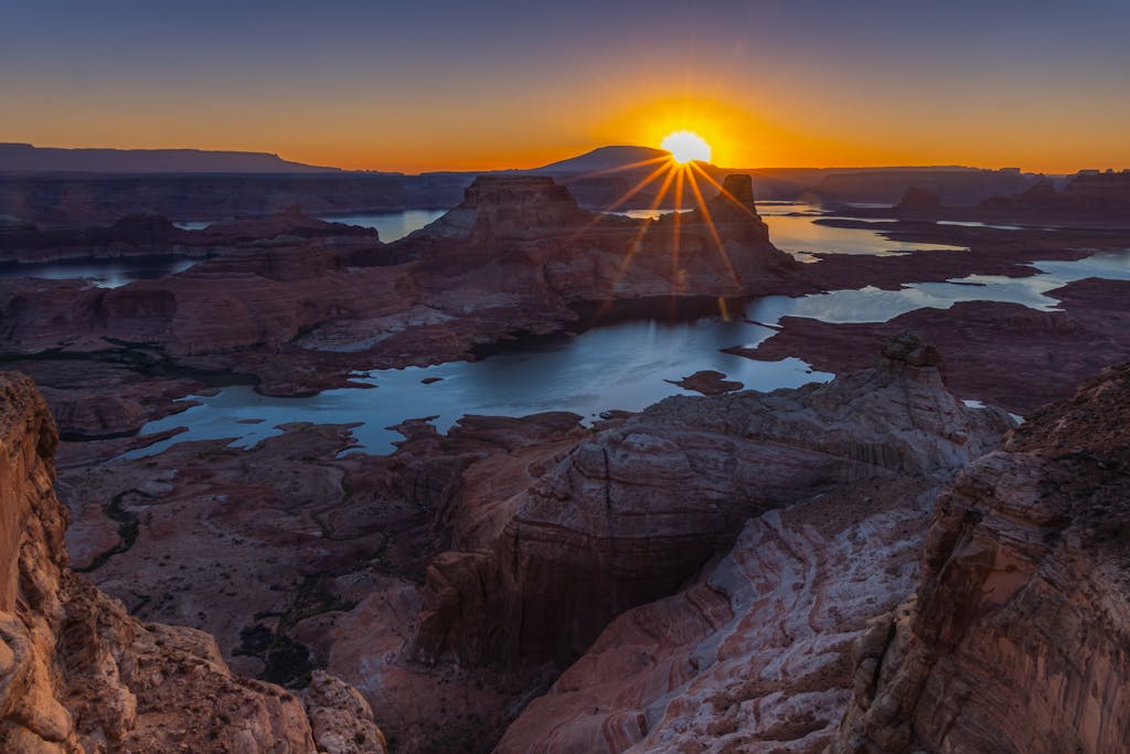 Breathtaking sunrise over Lake Powell and Alstrom Point canyons in Utah, capturing natural beauty.
