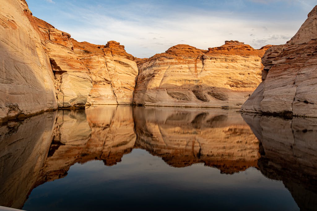 Stunning rock formations reflected in the calm waters of Lake Powell, Utah, at sunset.