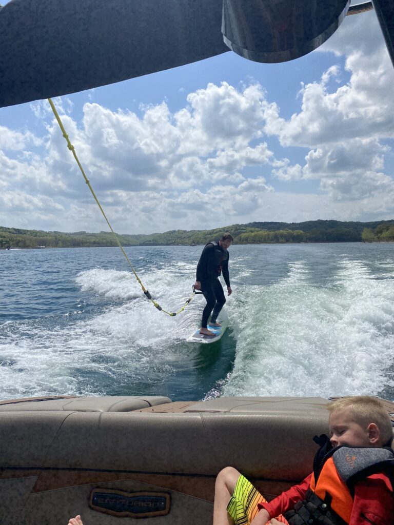 Surfing in a wet suit behind a boat on Table Rock Lake