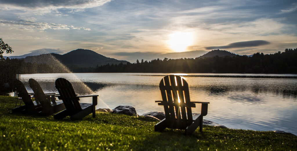 Mirror Lake at Sunset with adirondeck chairs in front of the water