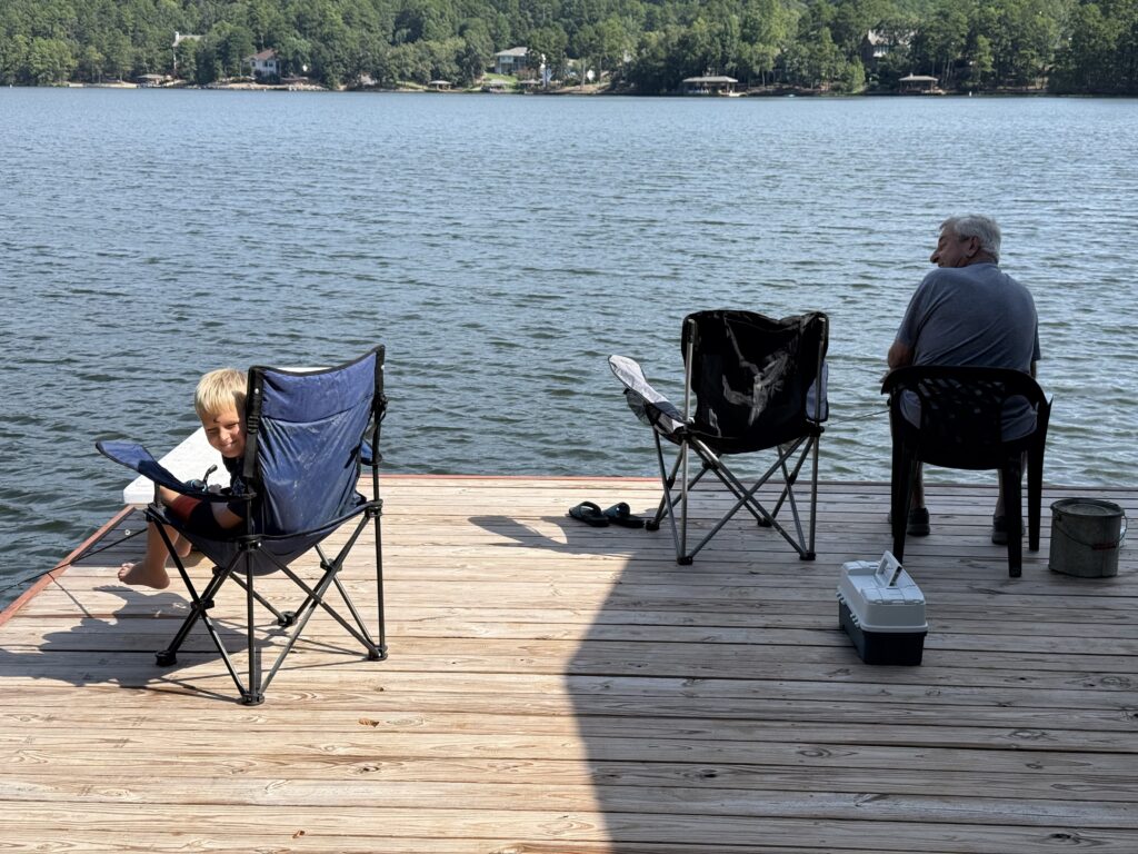 Boy with Grandpa sitting on the dock fishing at the Lake in Arkansas